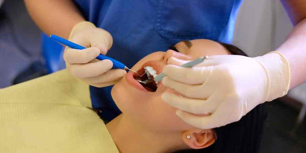 dentist-hands-working-young-woman-patient-with-dental-tools (1)-min porselen-dolgu